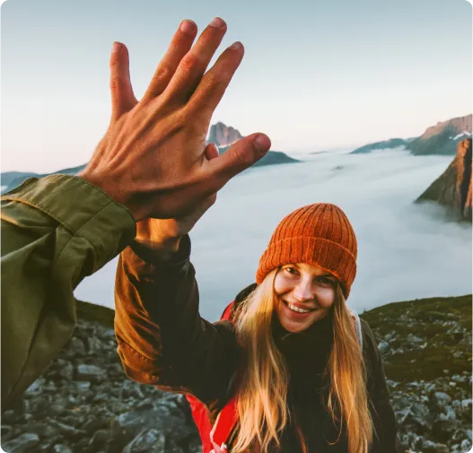 Smiling woman high-fiving her travel partner Smiling woman high-fiving her travel partner