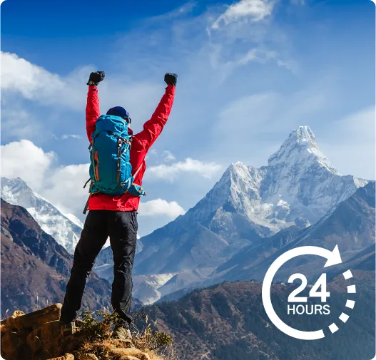 Traveller looking out over a mountain range and celebrating successfully climbing a peak. 