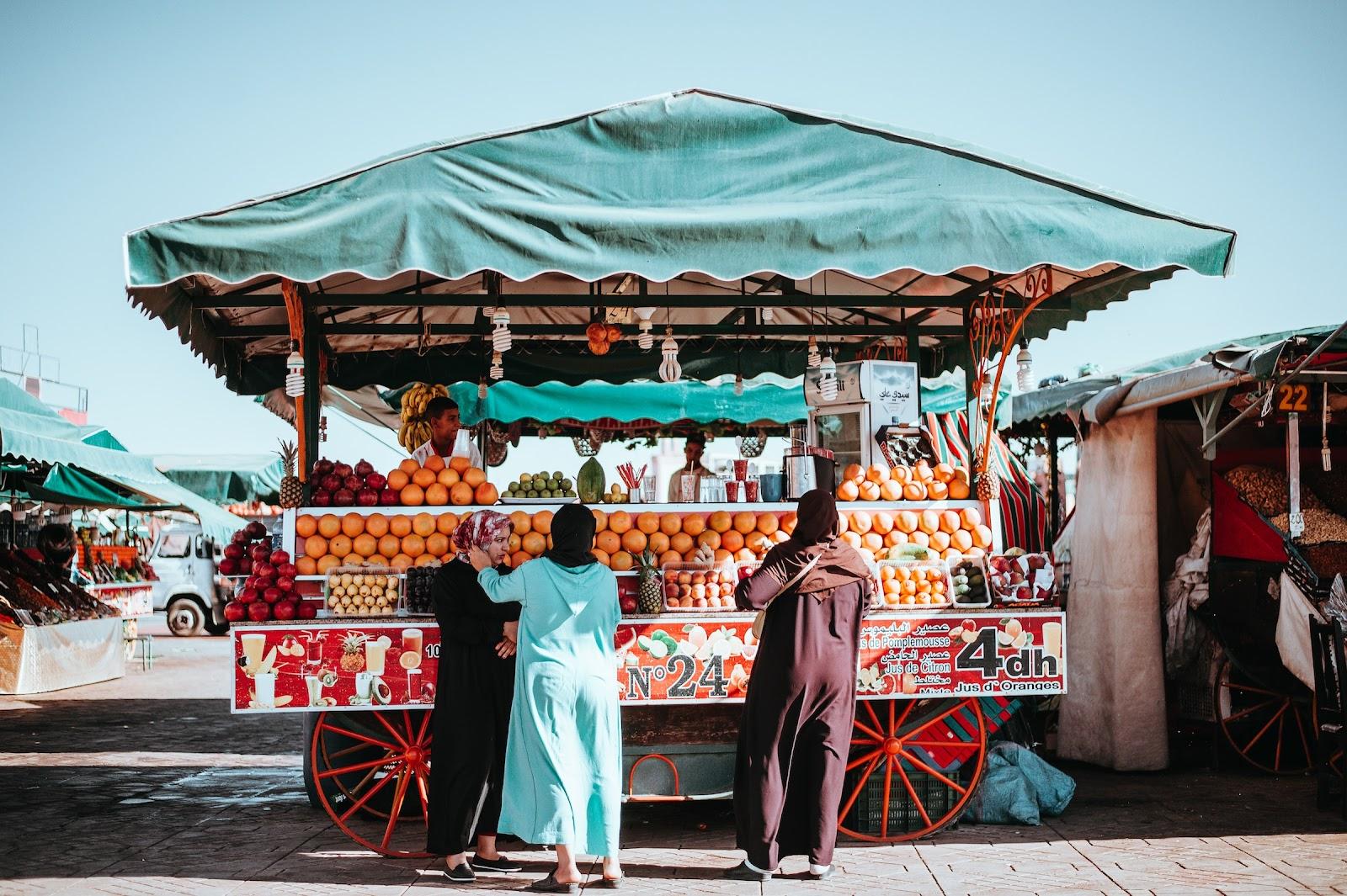 Locals buying fruit from a market stall on the streets of Marrakech. 