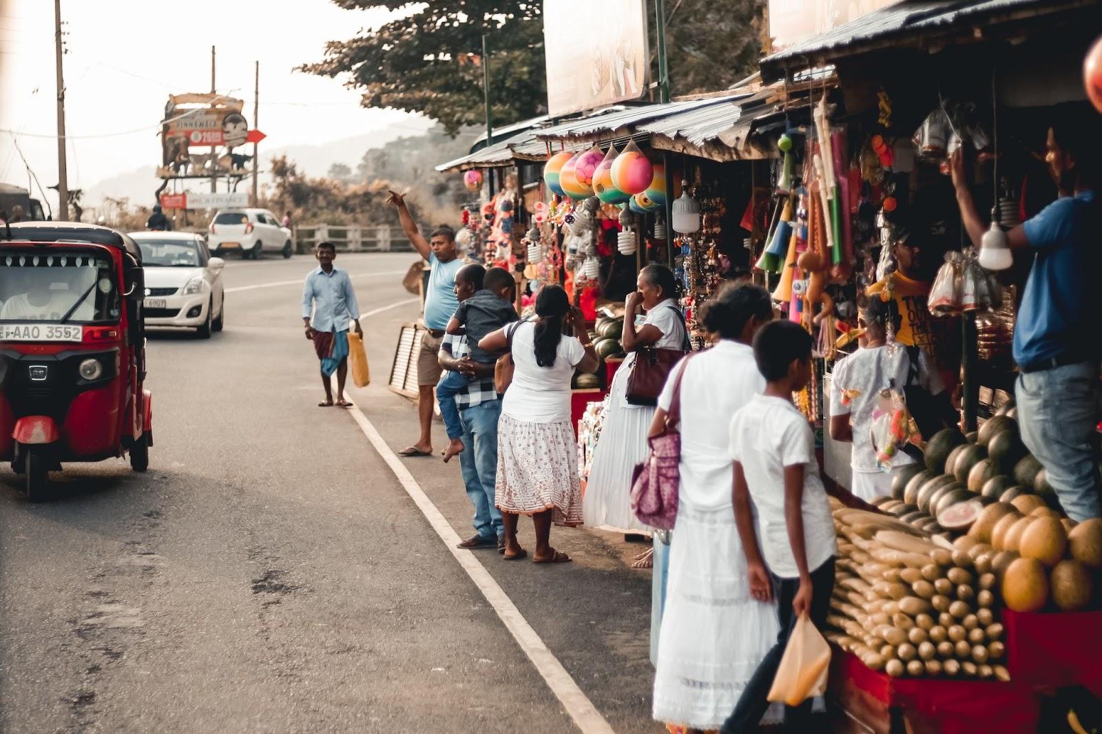 Locals buying fruit, veg and other items from street vendors in Sri Lanka