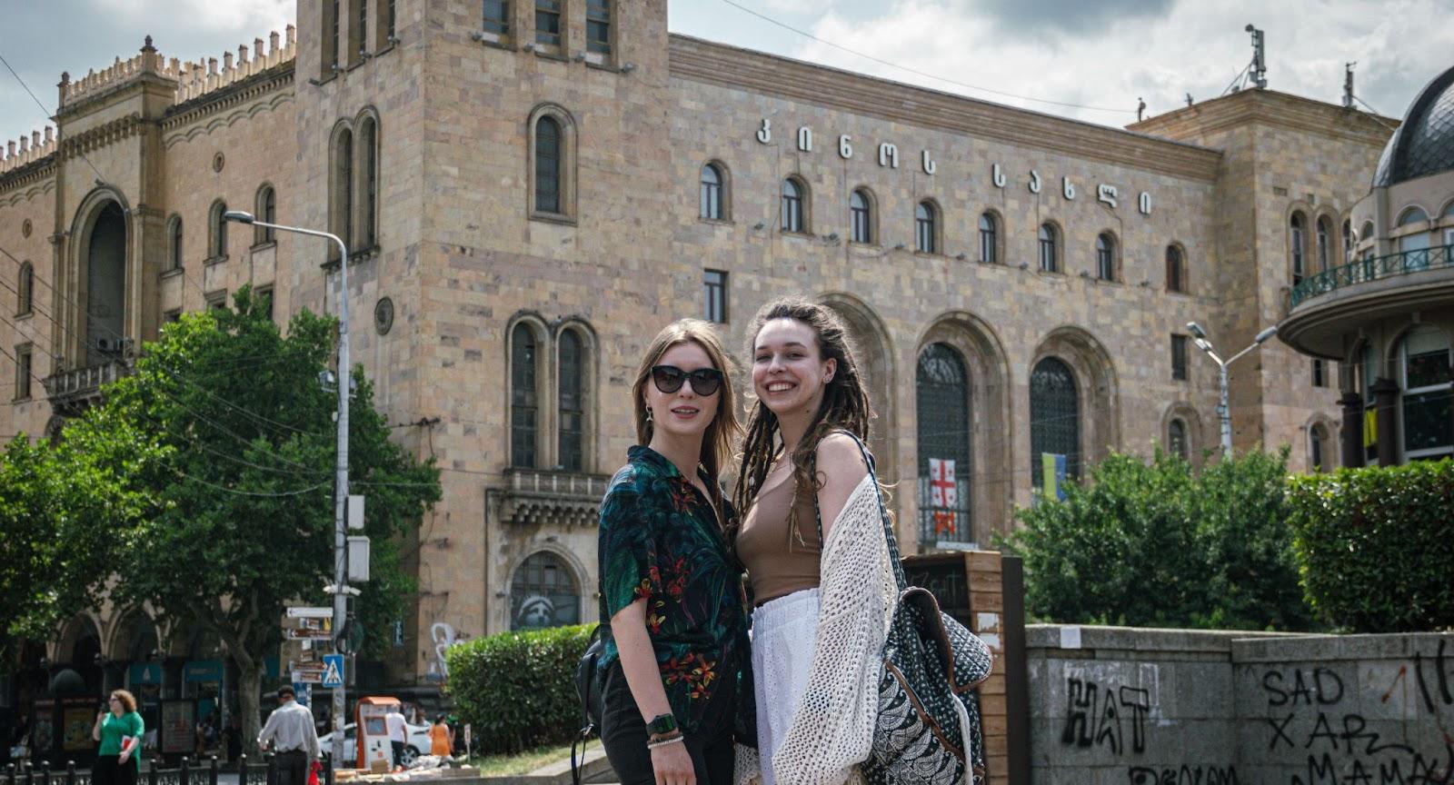 Two women posing for a photo in a street in Tbilisi