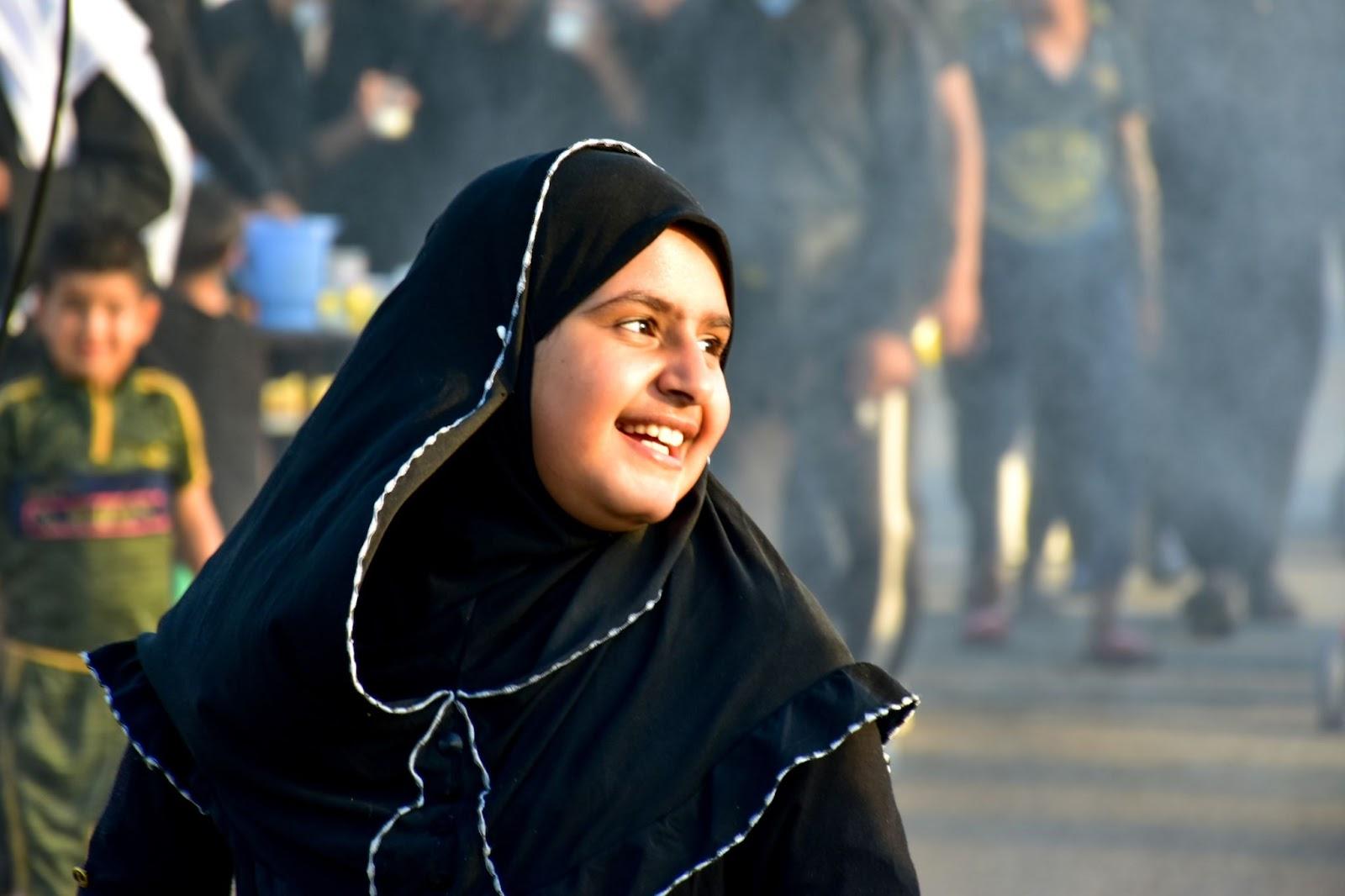 Smiling Iraqi girl wearing a traditional black hijab