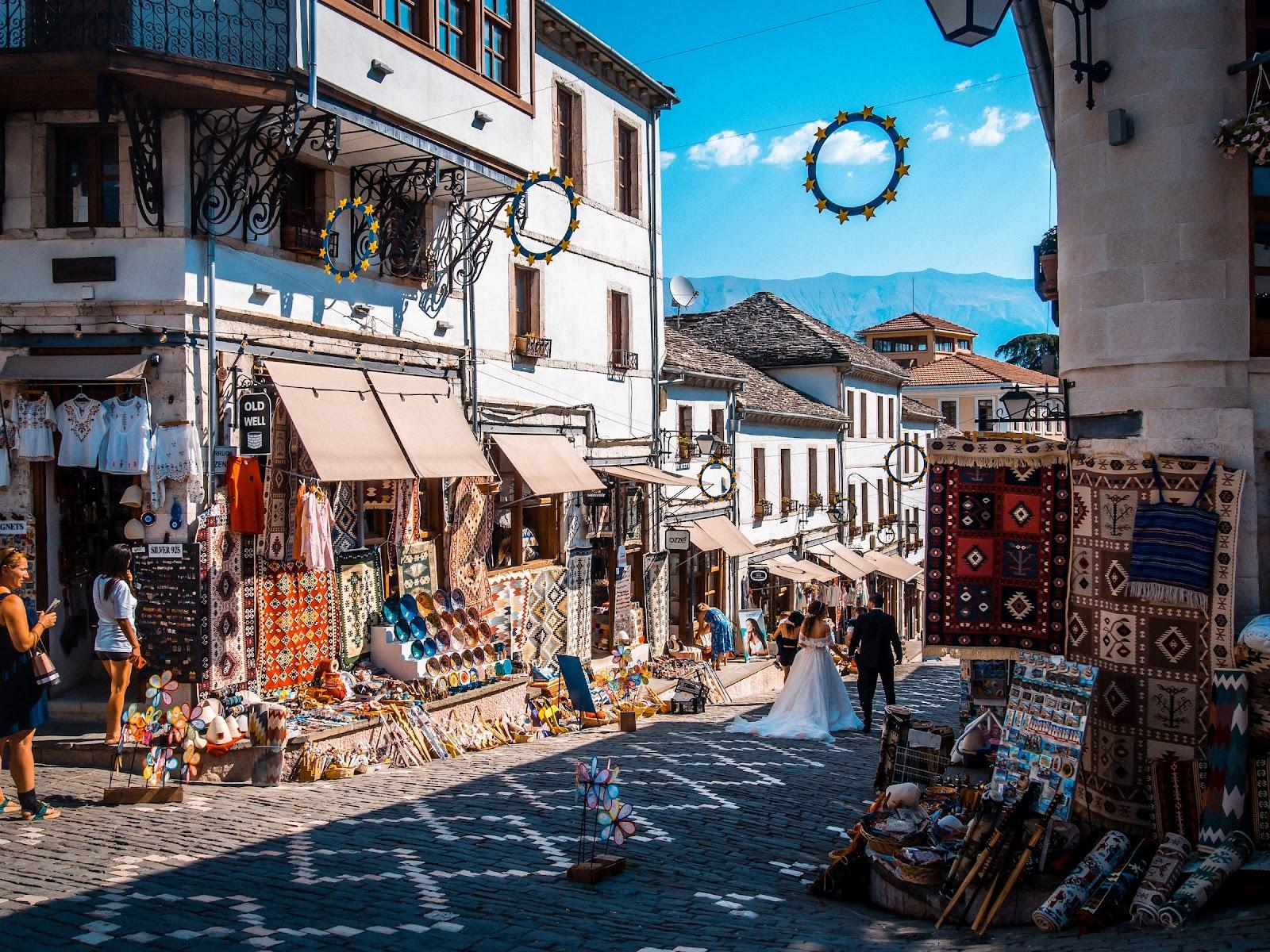 a married couple walking through the town of Gjirokastër, a city in southern Albania.