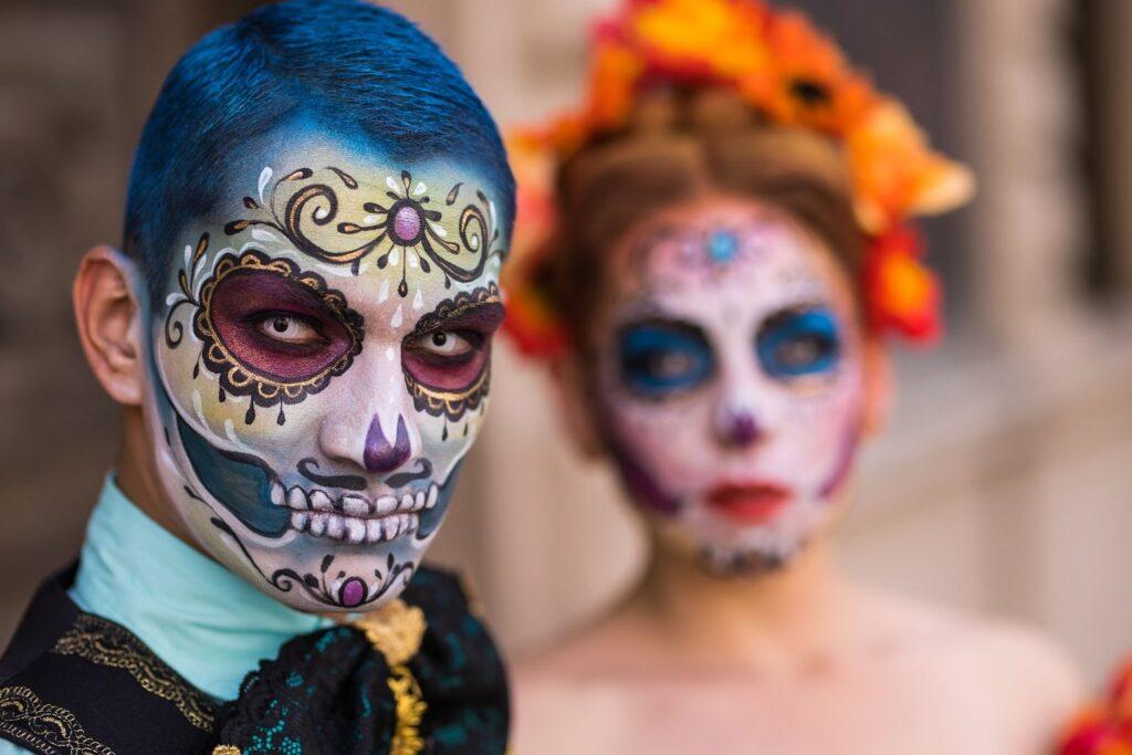 Man and woman with their faces painted for Día de los Muertos