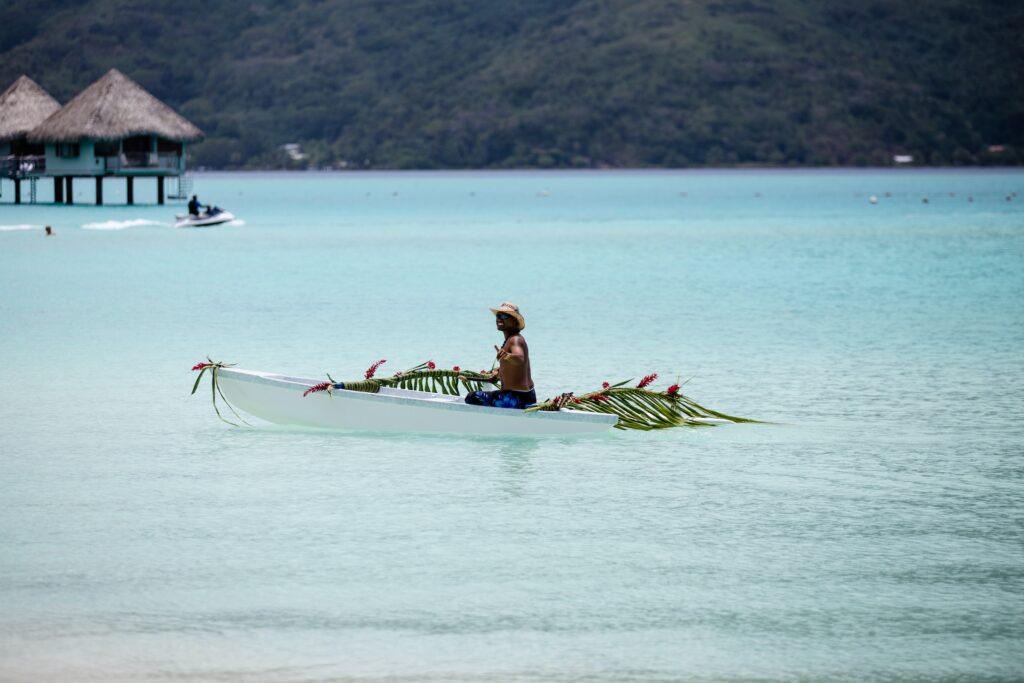 Local rowing his small boat off the coast of French Polynesia
