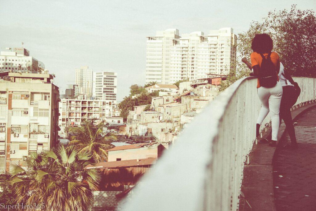 Couple leaning on metal handrails looking out over Central African city