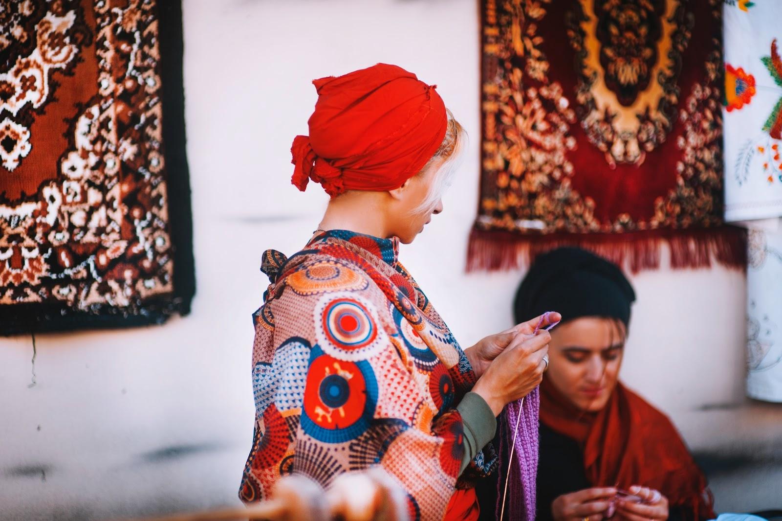 Georgian woman wearing traditional clothing, hand weaving carpets