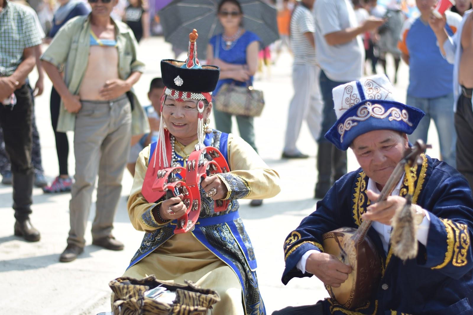 A group of Mongolian musicians play for locals in a market square.