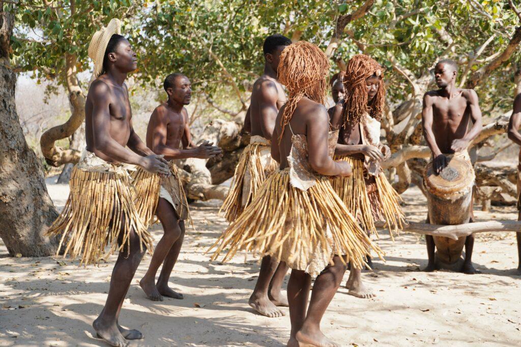 Botswana men dancing wearing traditional clothing in the Okavango Delta