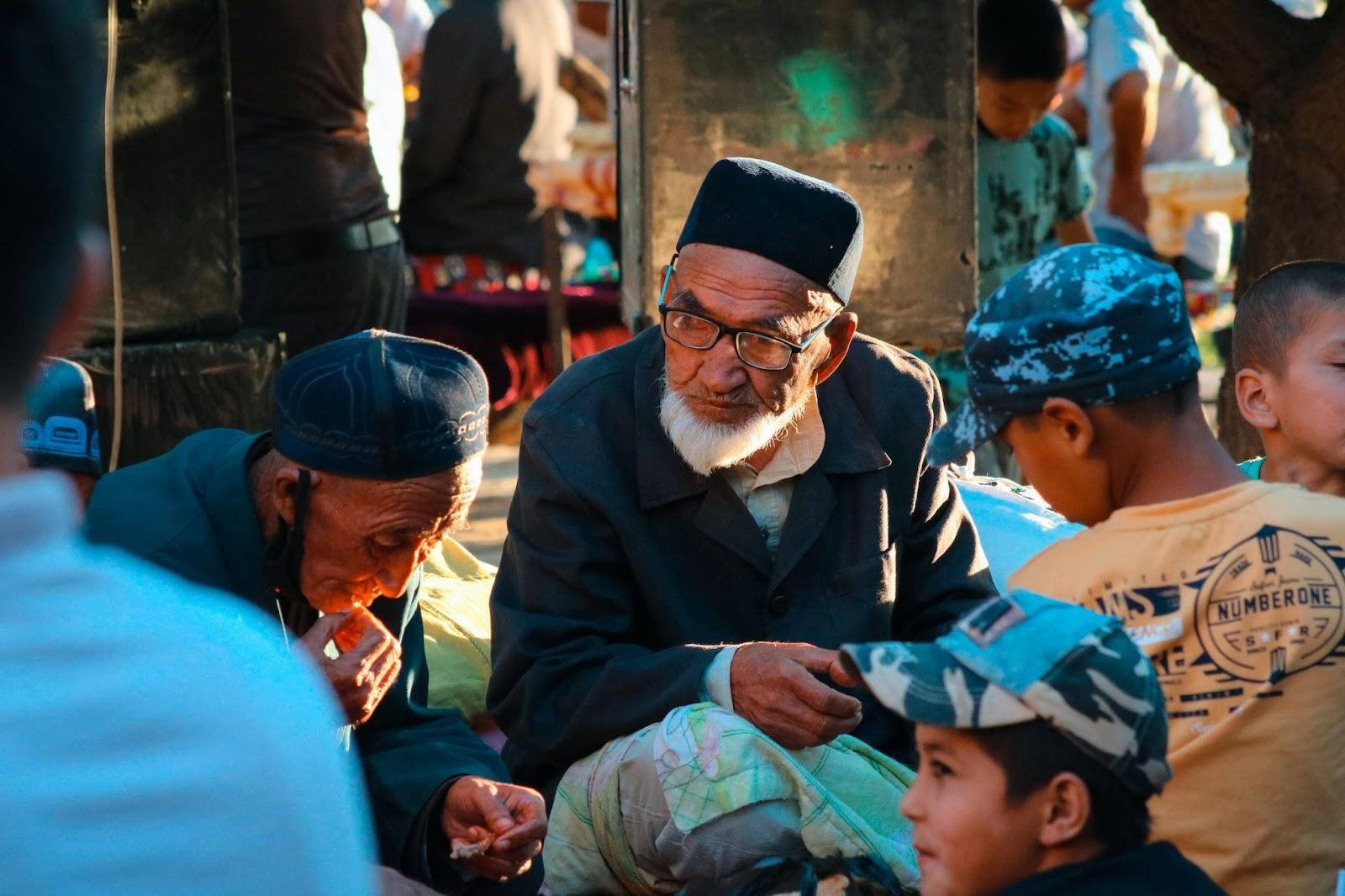 A group of Uzbekistani men, women and children sitting together.