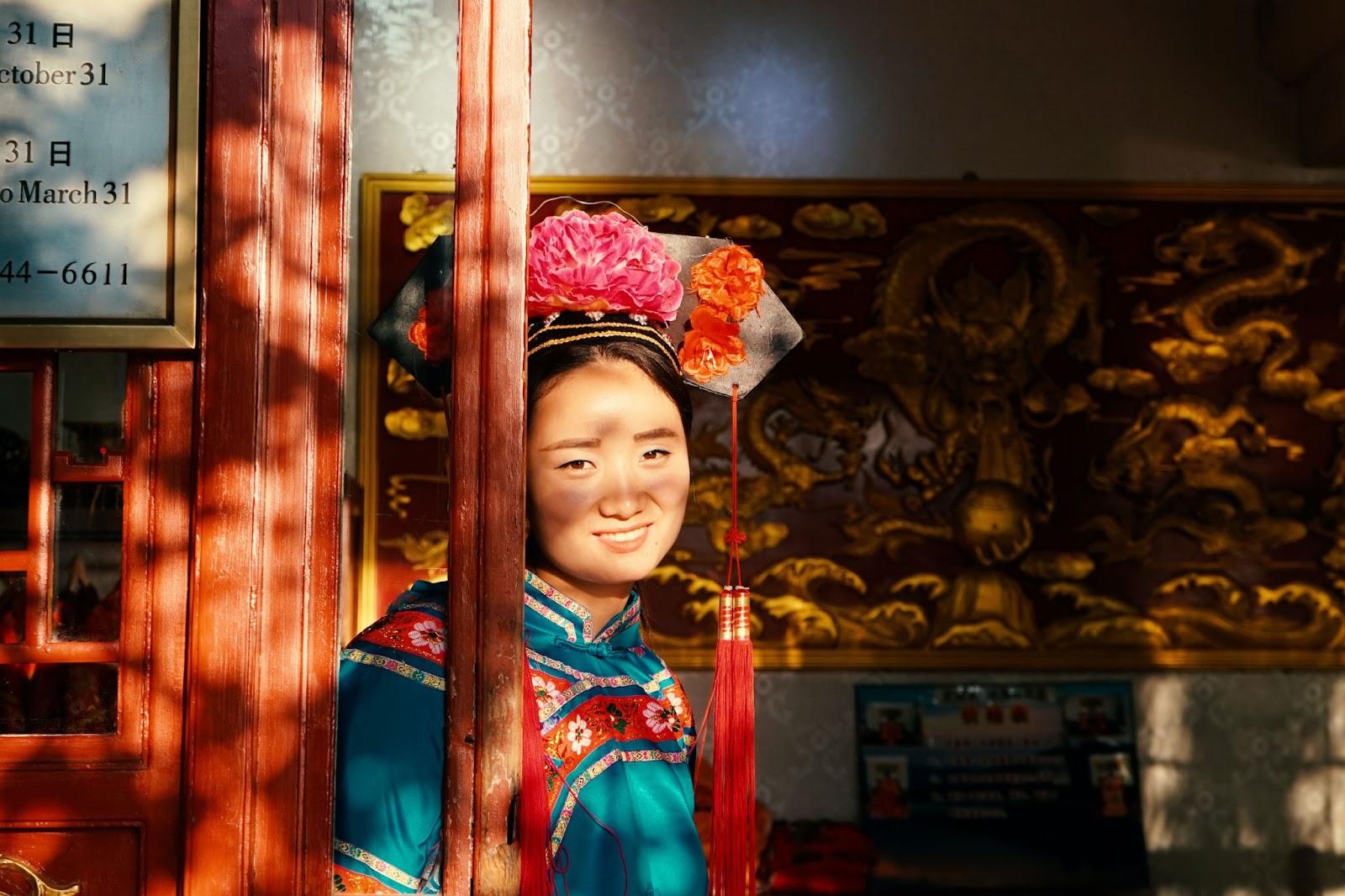 Chinese woman in traditional dress standing in the doorway of a temple