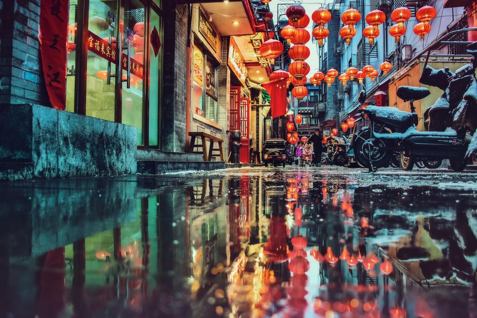 China town in the rain, reflections of red lanterns in puddles