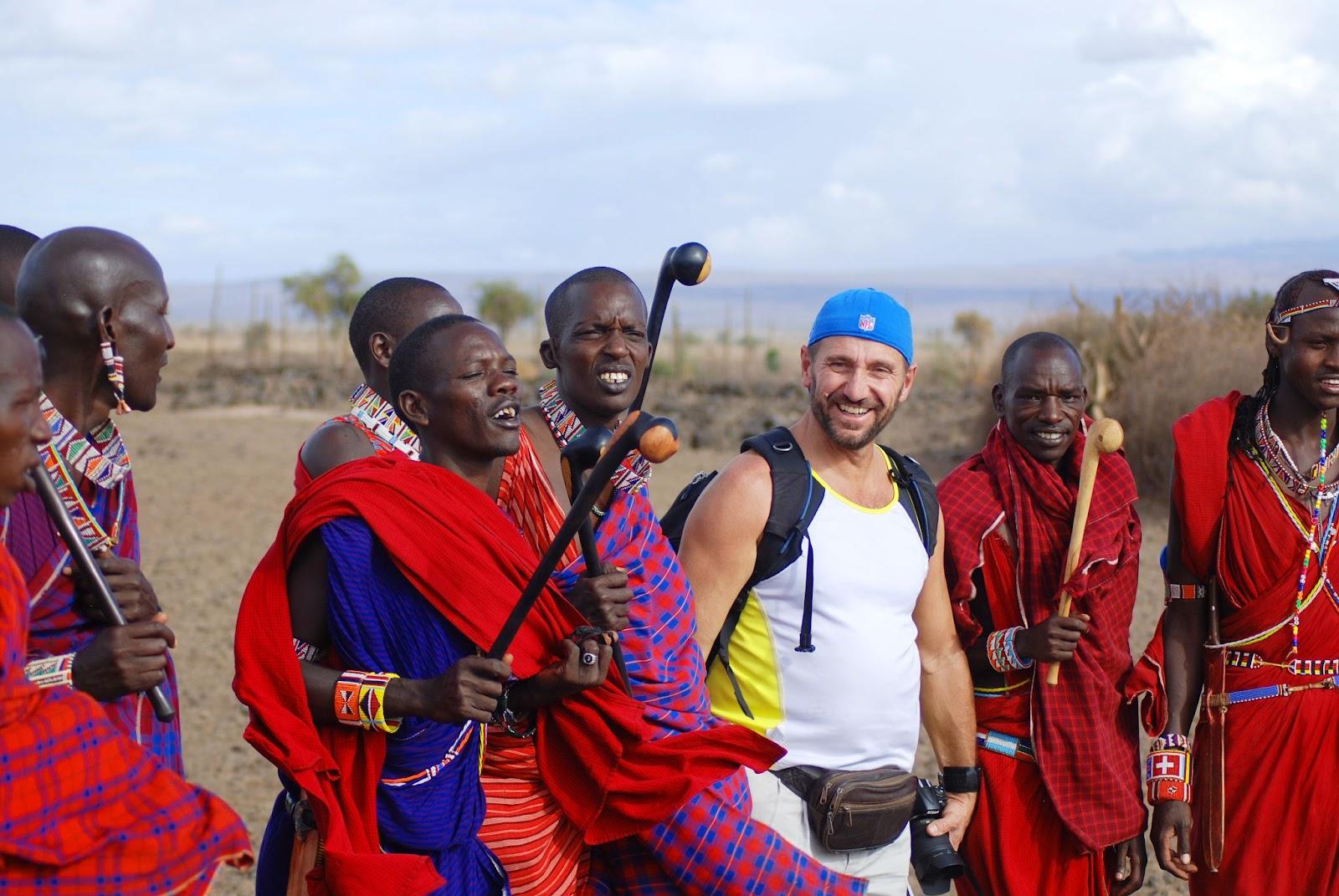 African men from Masai tribe dance with a tourist during a traditional show supporting the local economy