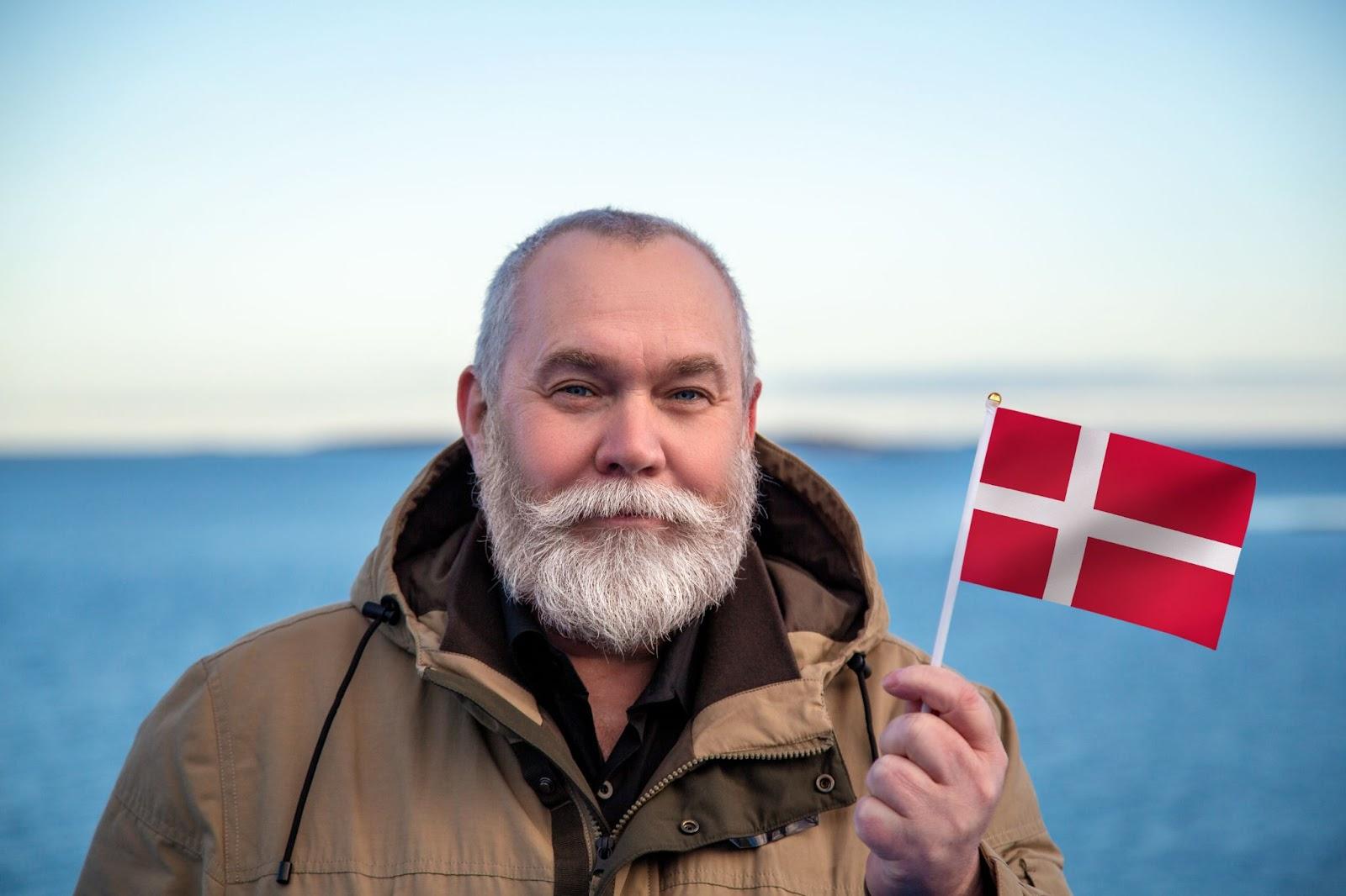 A Danish man holding a Danish flag.