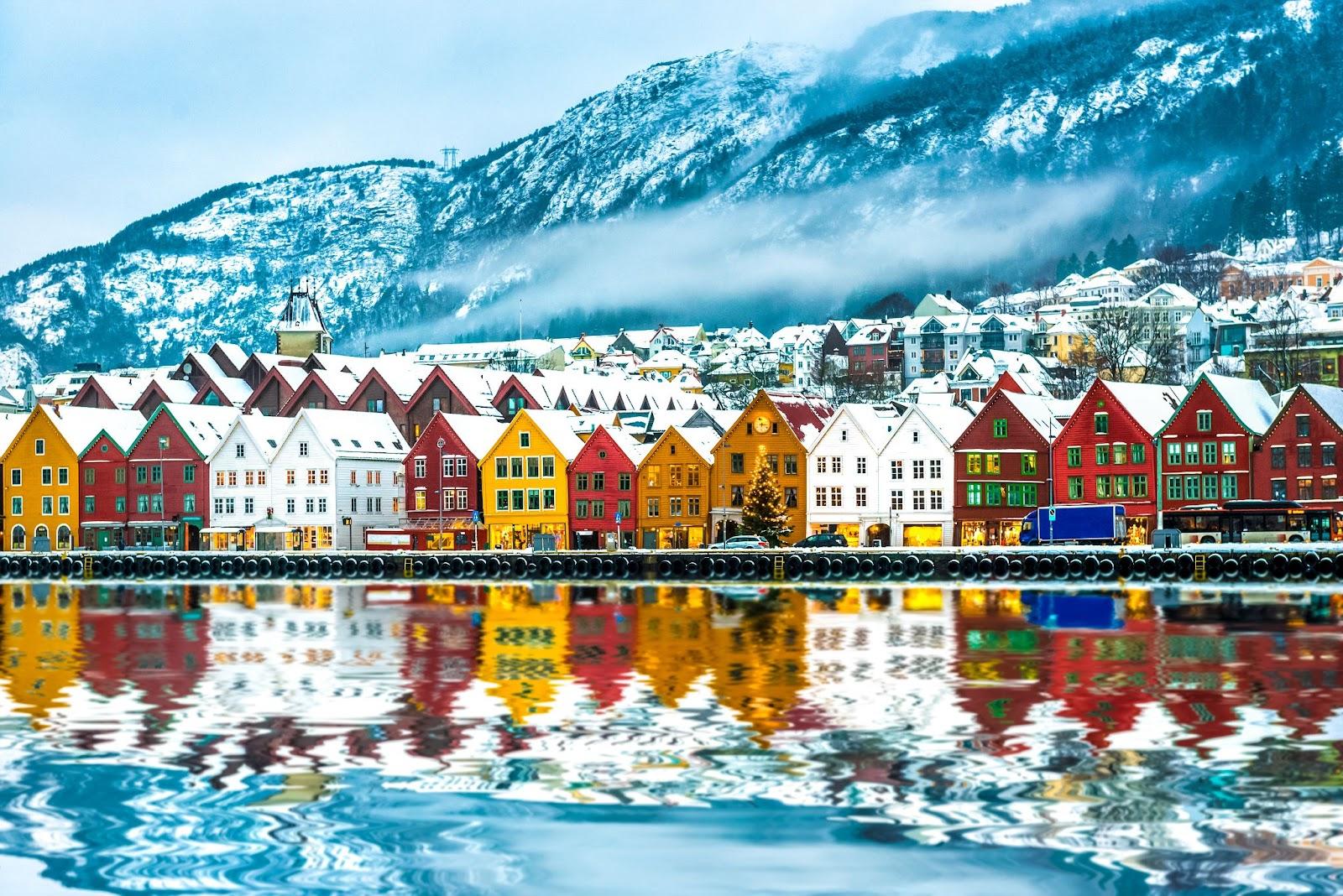 A row of colourful houses next tot he sea in Norway . 