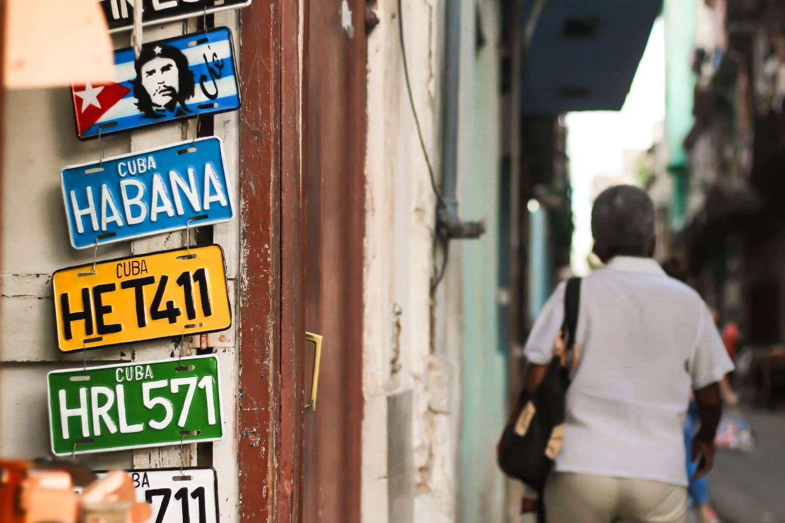 car number plates hanging on a wall in the street of Cuba