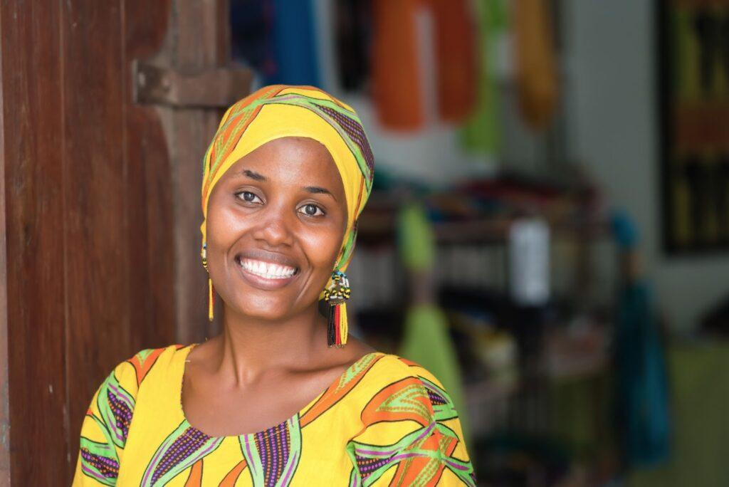 A smiling Tanzanian women in colourful clothes.