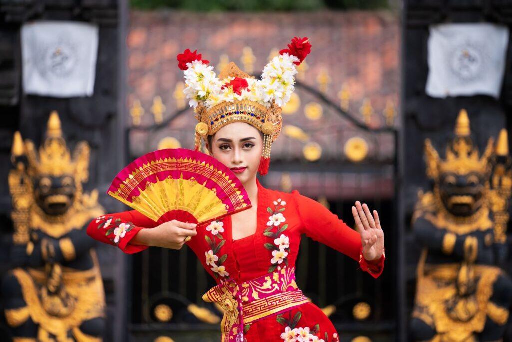 An Indonesian women in traditional address performing a dance.