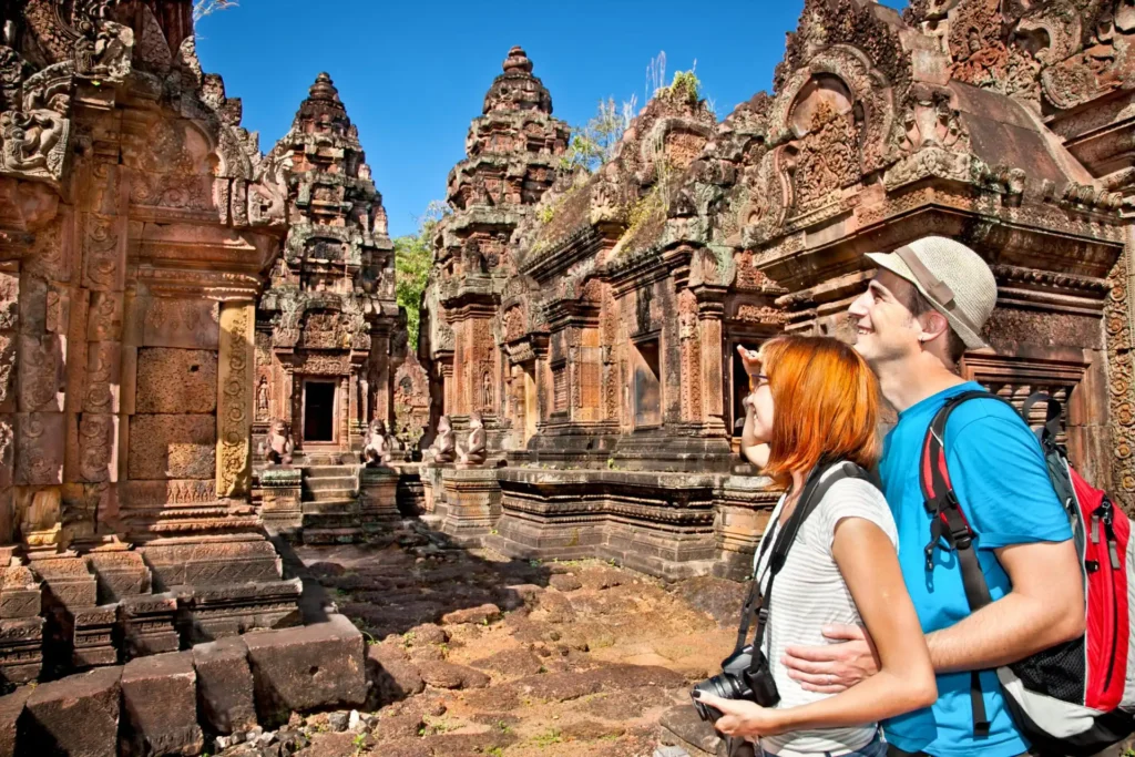 Couple at Banteay Srei temple in pink sandstone. Angkor wat complex, Cambodia.