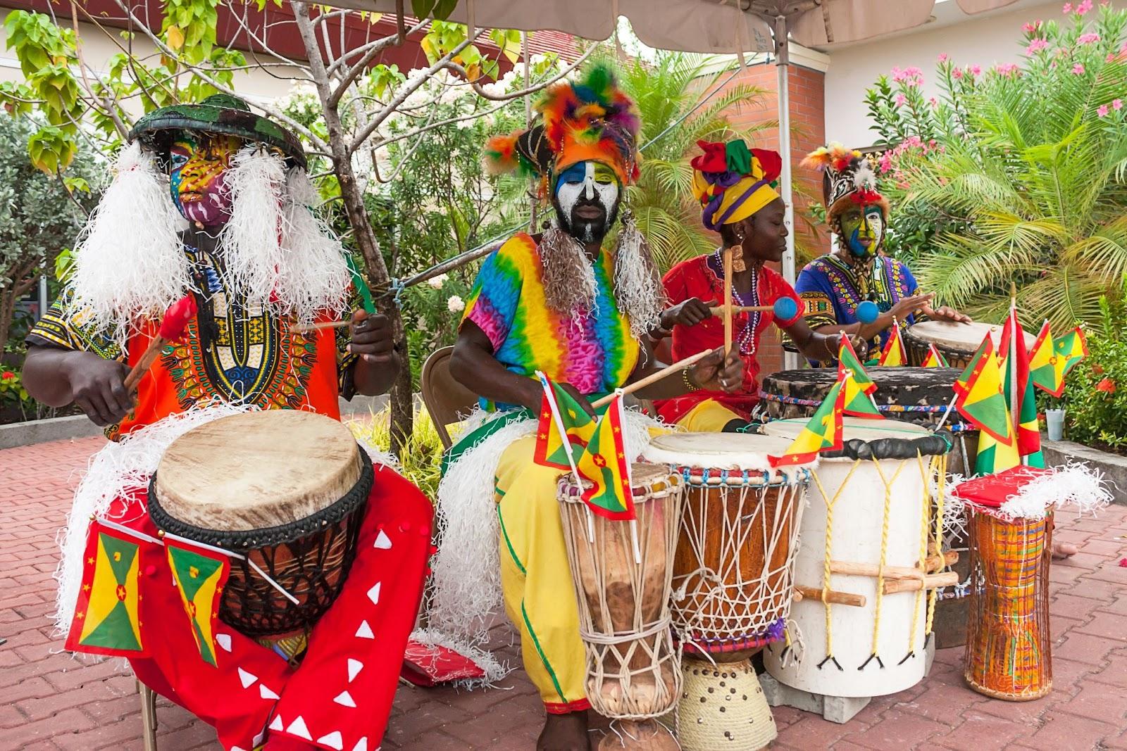 Musicians dress with typical costumes and makeup are playing african drums at St. georges harbor in Grenada. East Caribbean