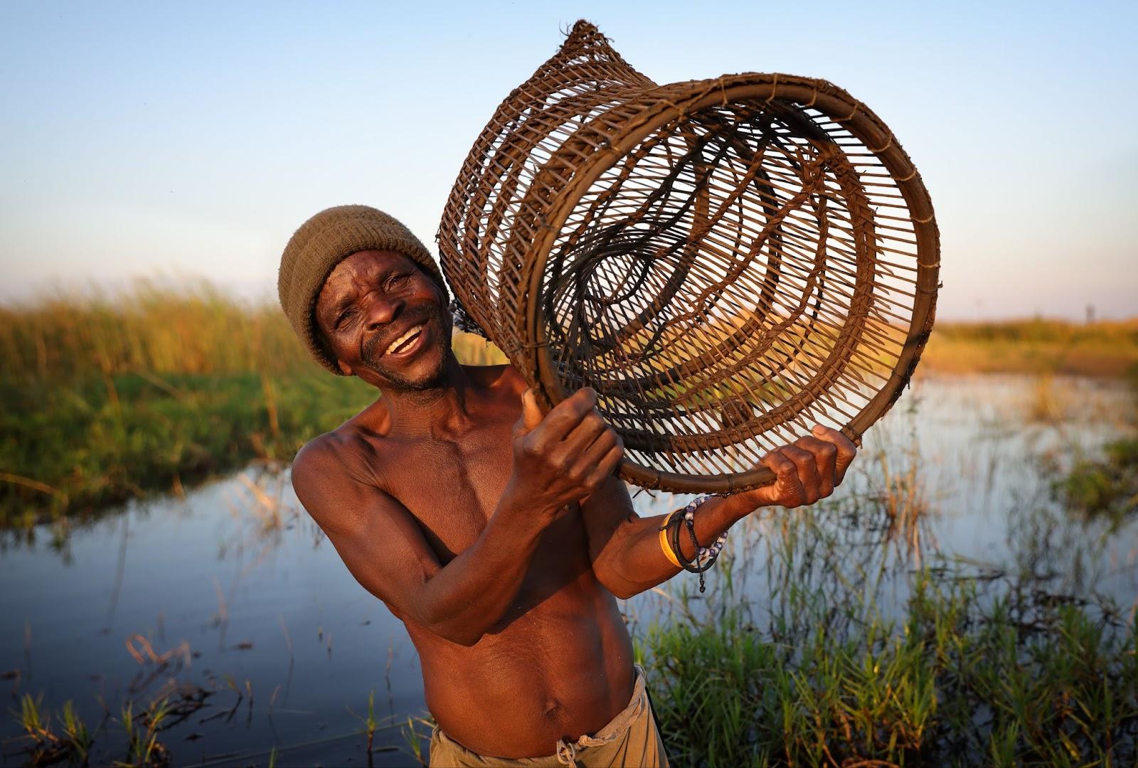 fisherman carries a fish trap on the waterfront of Lake Malawi.