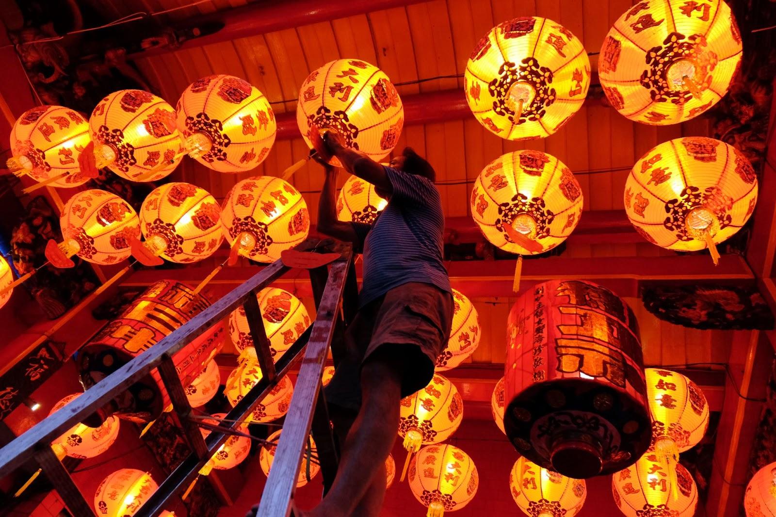Person hanging up lanterns for Lunar New Year