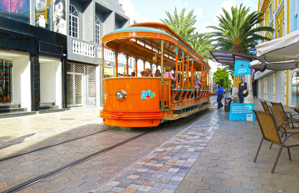 Tourist boarding and riding on Free City Trolley / Street Car in Oranjestad, Aruba.