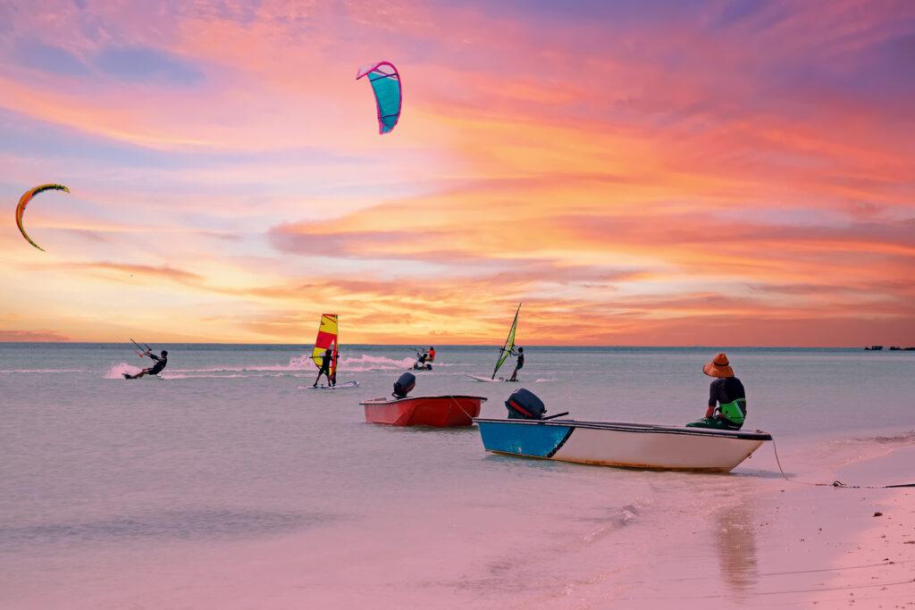 Watersports at Palm Beach on Aruba island in the Caribbean Sea at sunset.