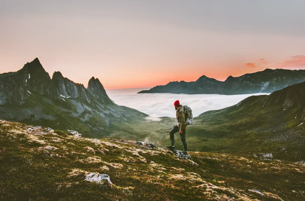 Man backpacker hiking in mountains alone on holiday in March