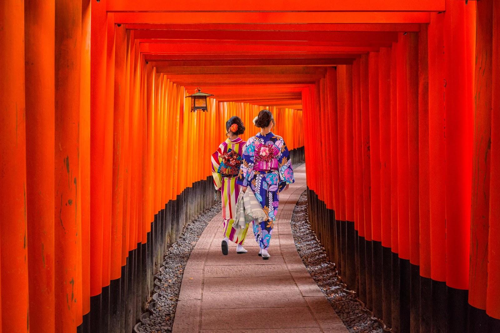 Women in traditional japanese kimonos walking at Fushimi Inari Shrine in Kyoto, Japan
