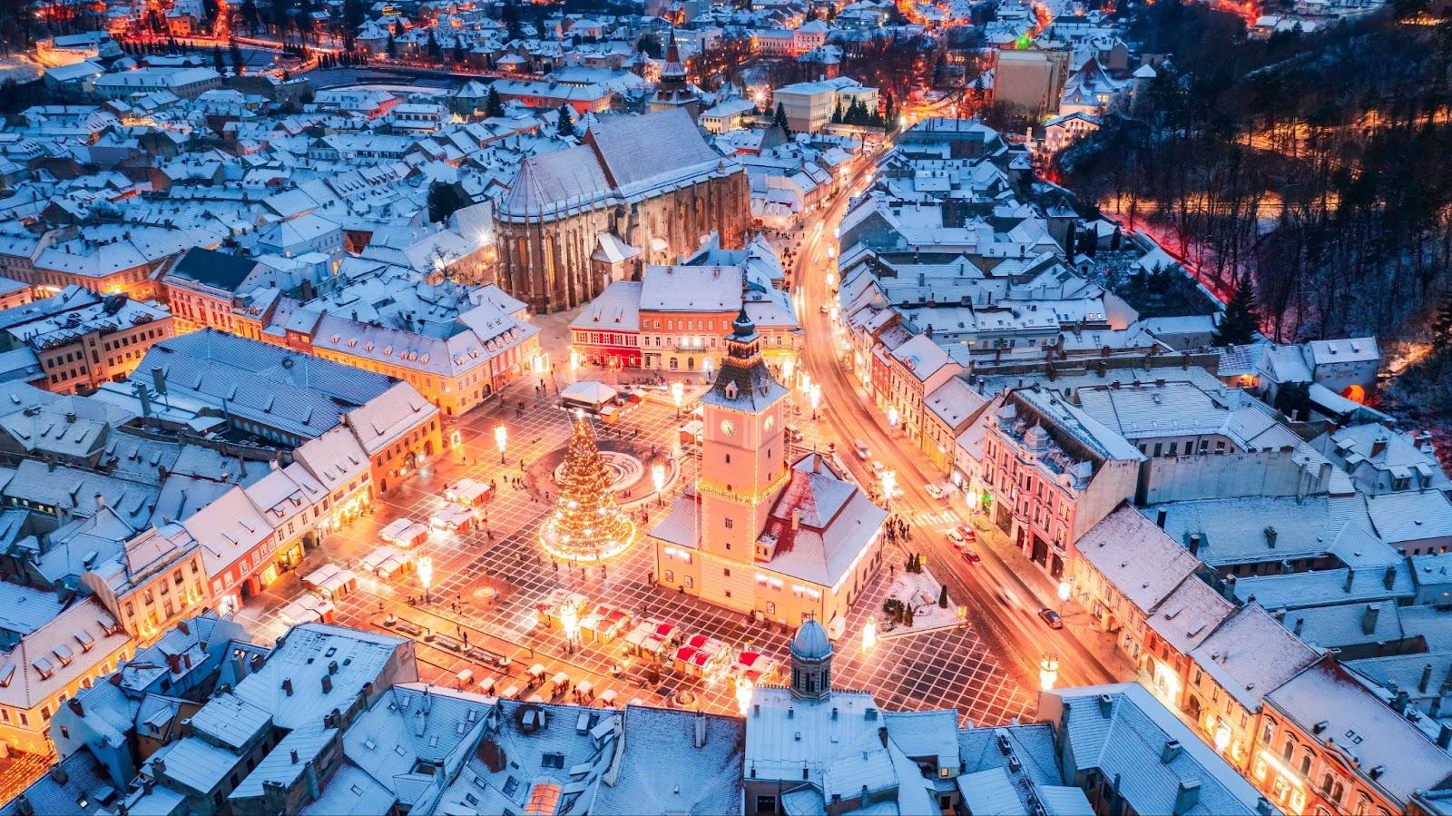 Brasov, Romania.  aerial view with snowy Christmas Market and Council Square, Transylvania landmark