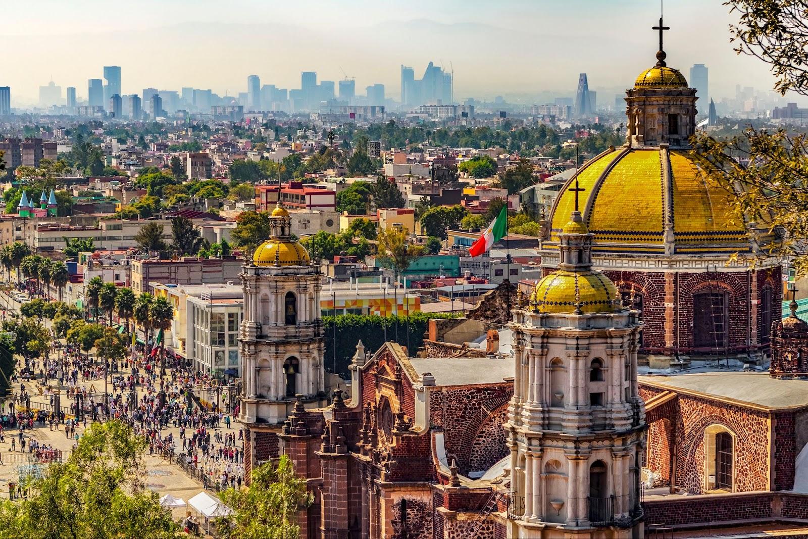 Basilica of Our Lady of Guadalupe. Cupolas of the old basilica and cityscape of Mexico City