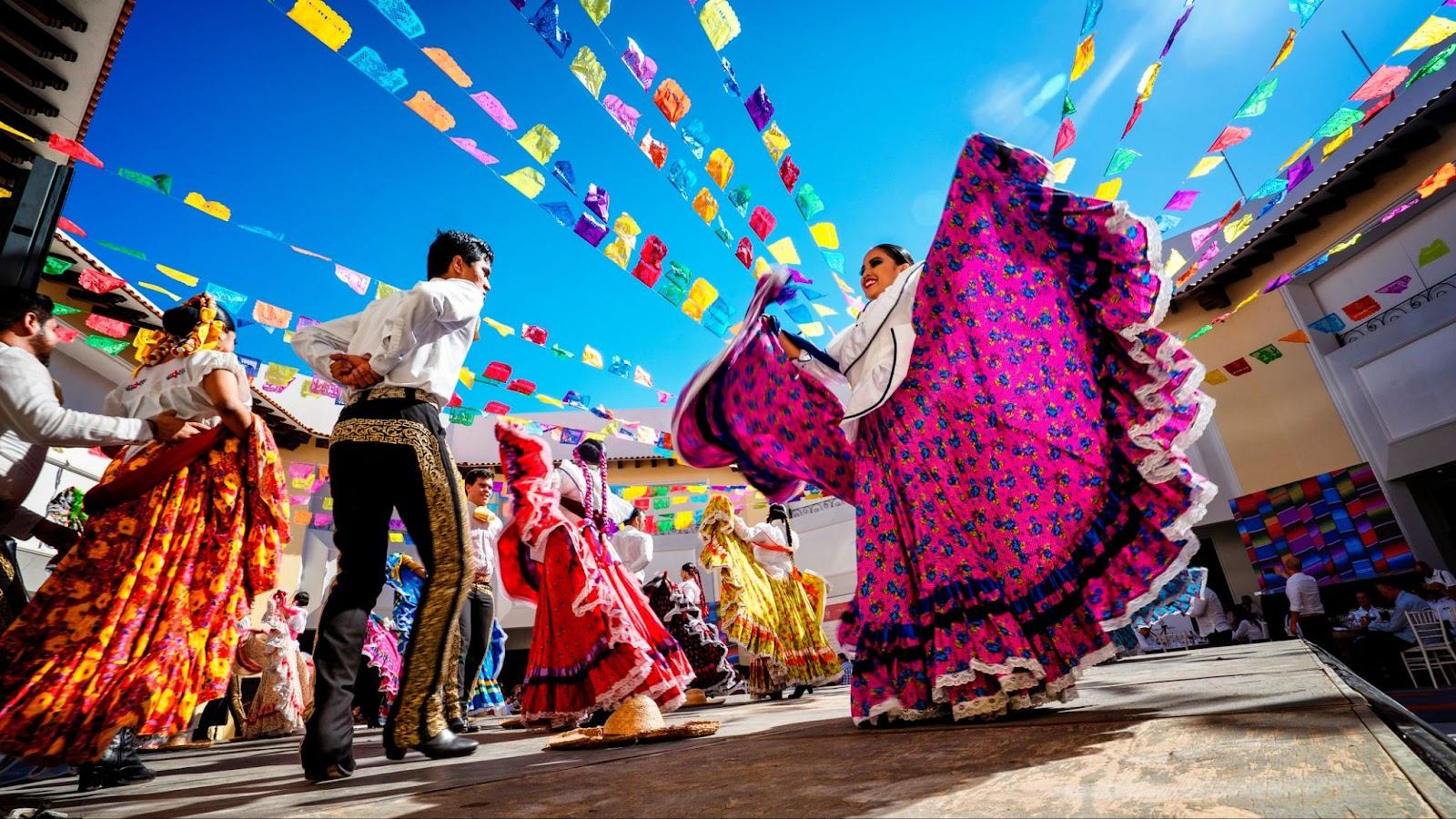 Photo of folklore dancers dancing in a beautiful traditional dress representing mexican culture.