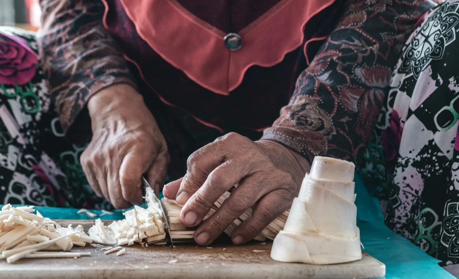 person in red and black long sleeve shirt holding white textile Tutong market in Brunei