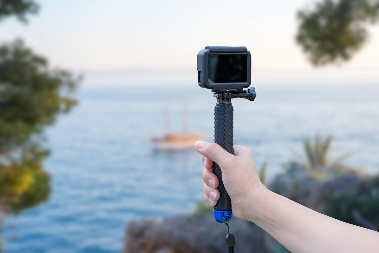 The girl makes a video on the vacation. Ship at sea in background using a tripod.