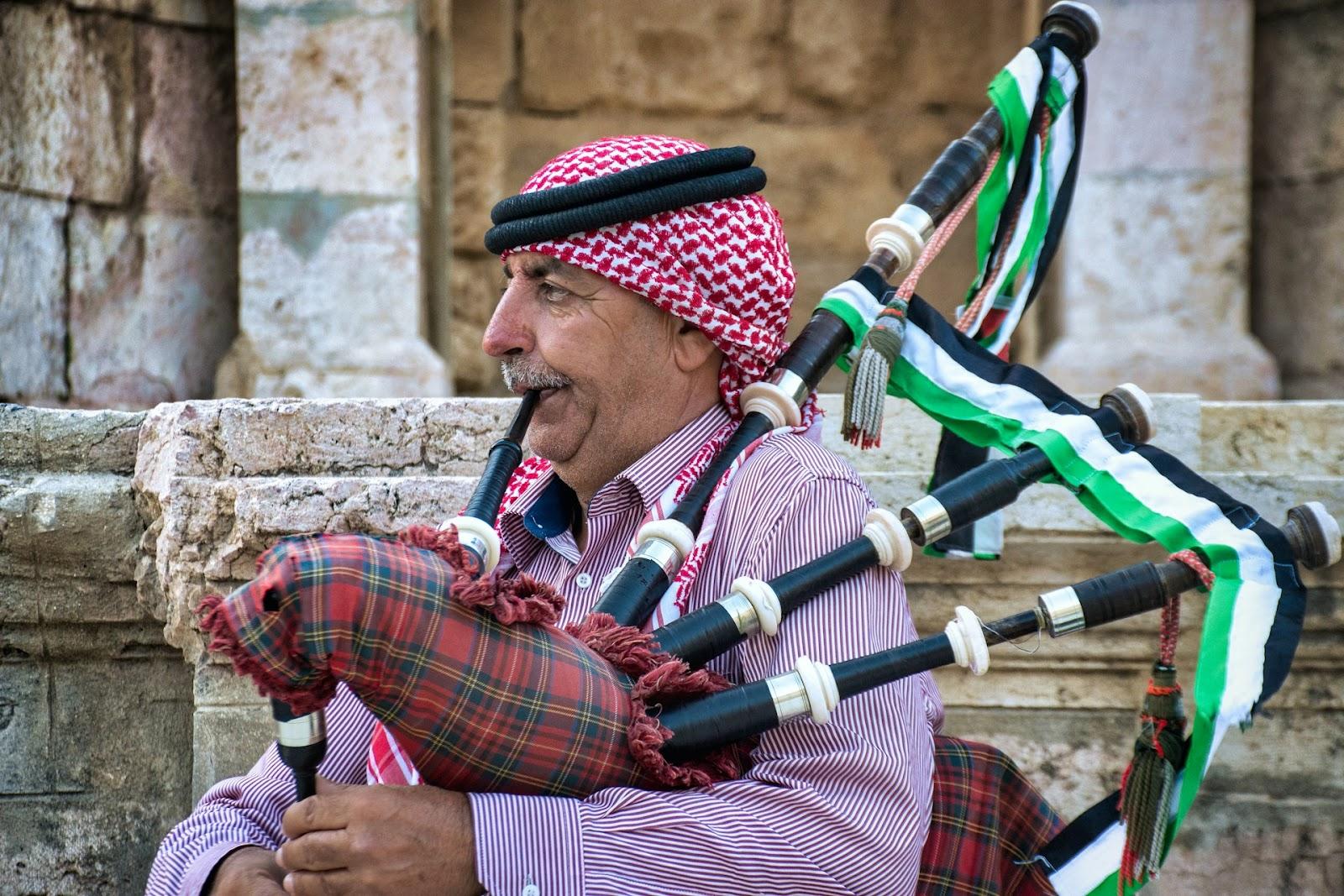 Jordanian man in traditional dress playing the bagpipes