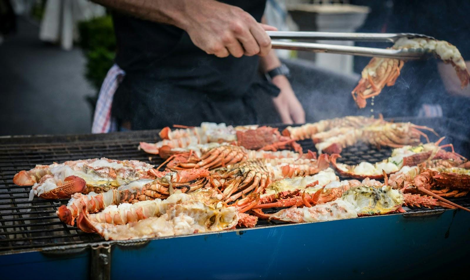 man grilling lobsters in New Zealand