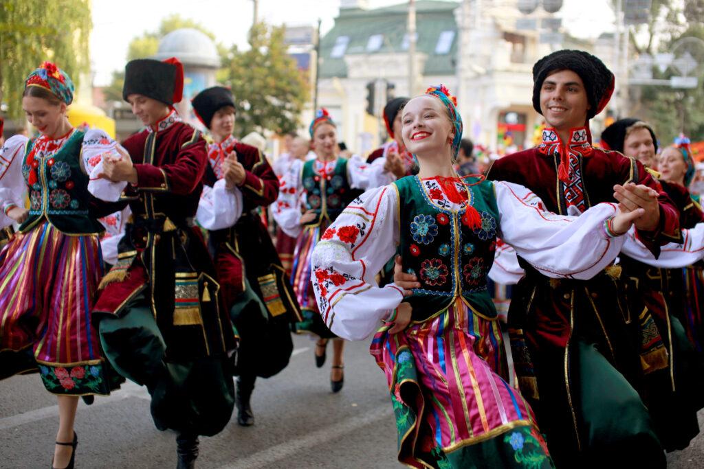 procession of students of the Institute of culture, dancers in Cossack traditional dress, colored skirt, green trousers and maroon jackets, Cossack hats Cossacks dancing.