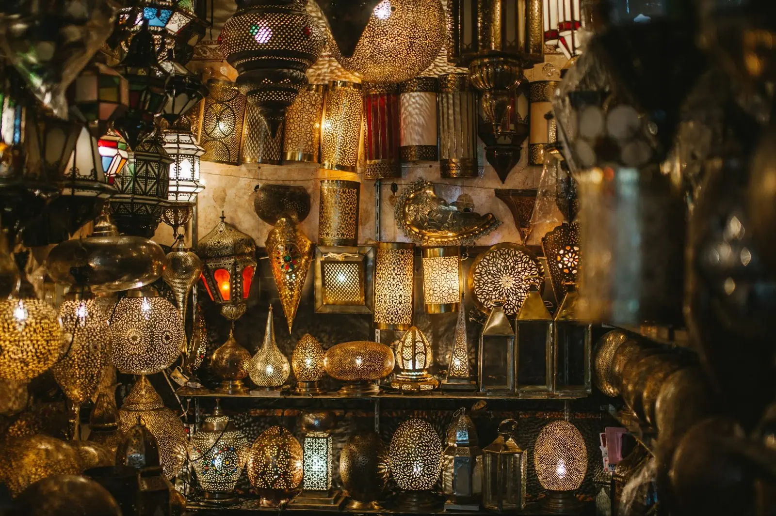 Moroccan lanterns lit up on a market stall in Marrakesh. Buy with Moroccan dirhams (MAD)