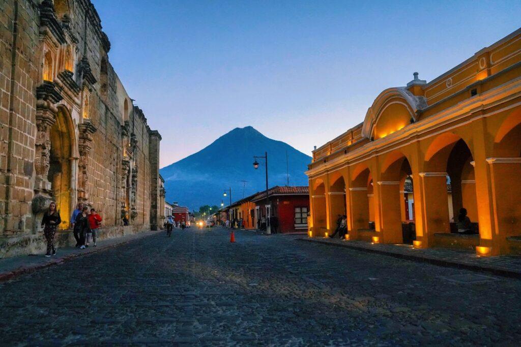 View down cobbled street in Antigua looking towards a volcano