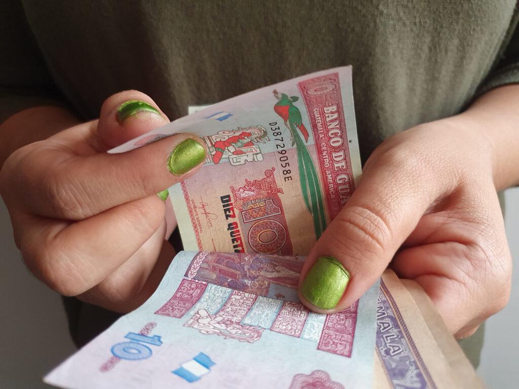 hands of a woman counting Guatemalan money