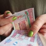 hands of a woman counting Guatemalan money