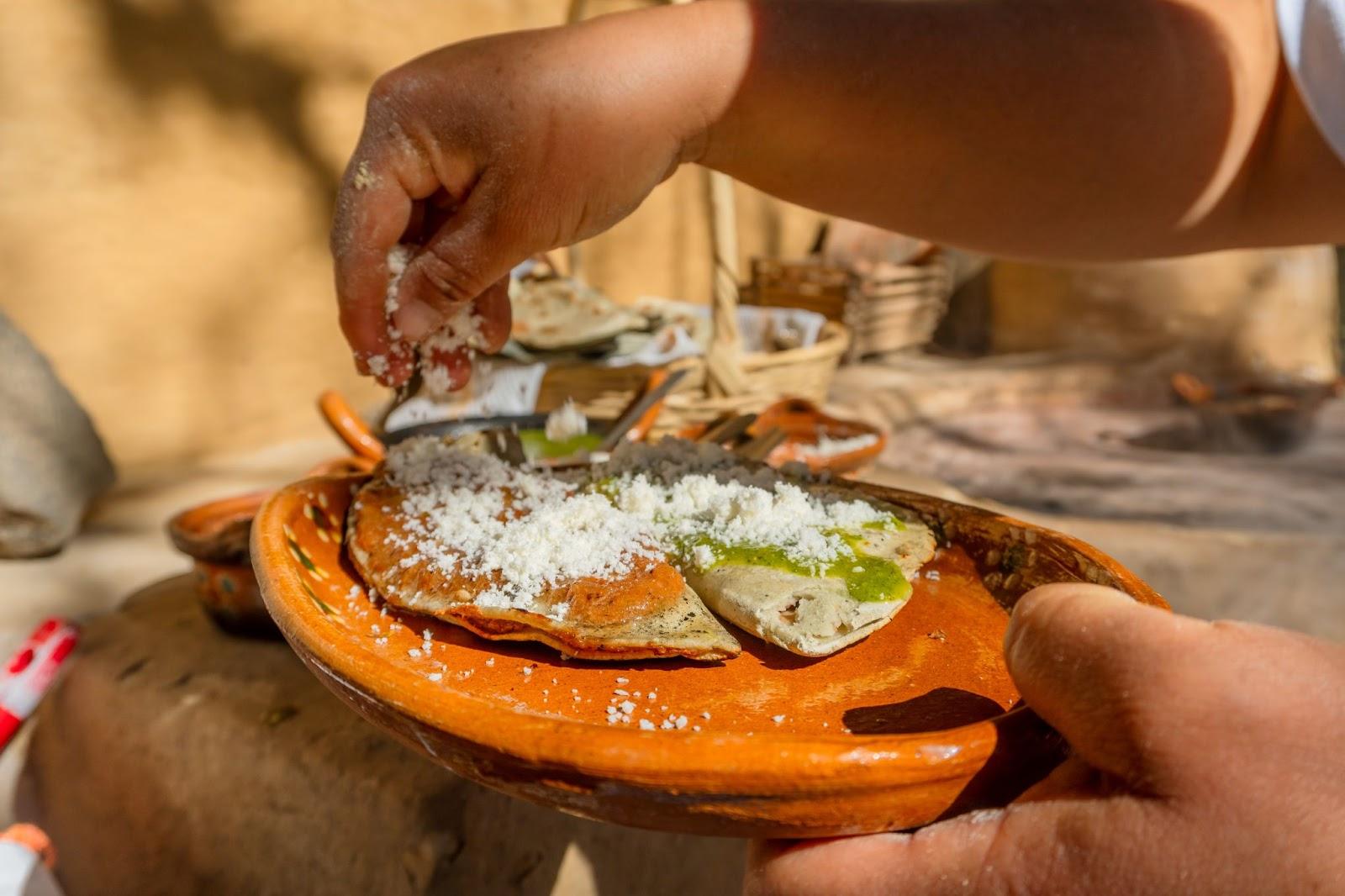 Traditional Mexican food: corn tlacoyo with beans and salsa