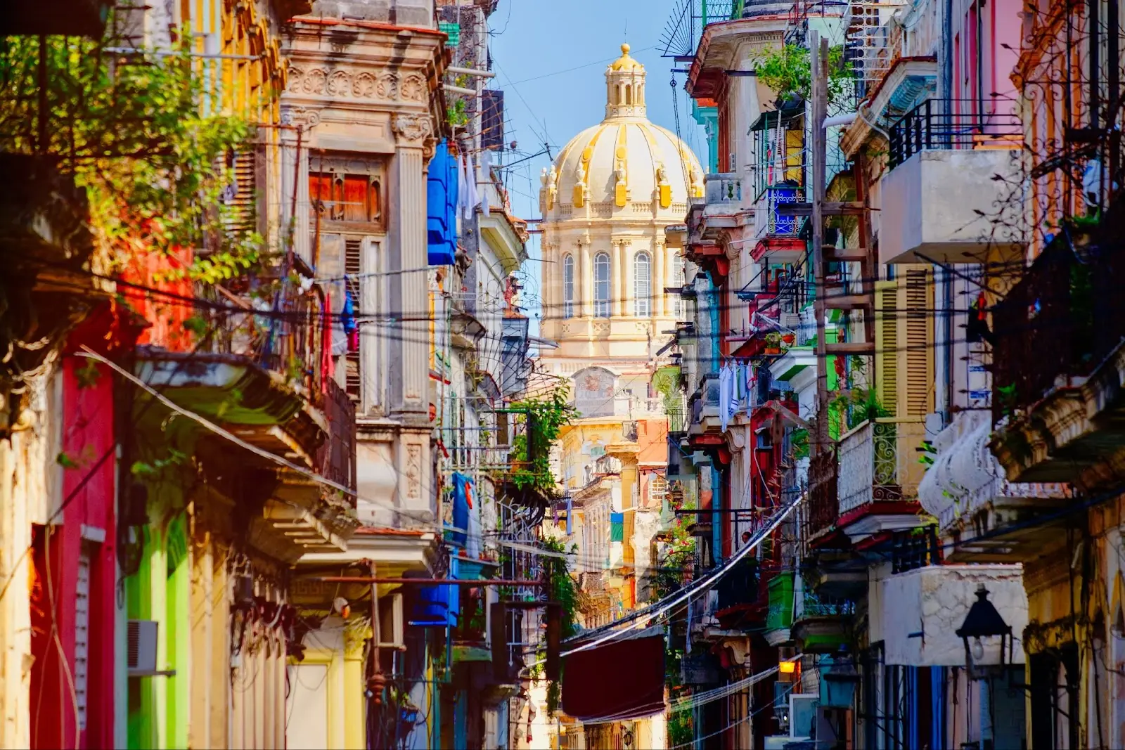 Colorful street in Old Havana city with the Presidential Palace on the background