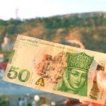 50 Georgian Lari Banknotes in Obverse Side in Hand with Blurry Tbilisi City View in Backdrop