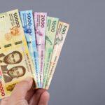Burundian money - franc in the hand on a gray background