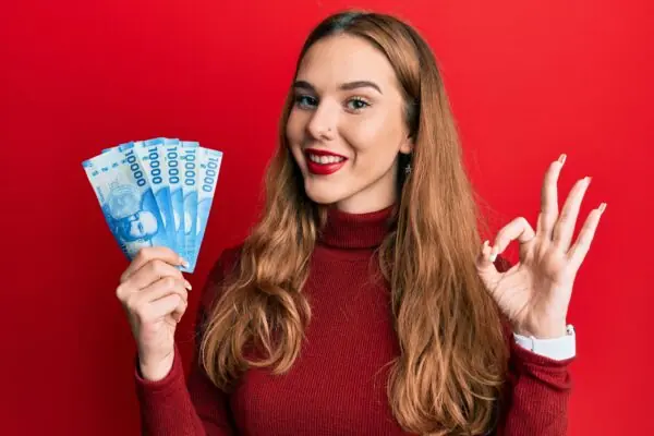Young blonde woman holding 10000 chilean peso.