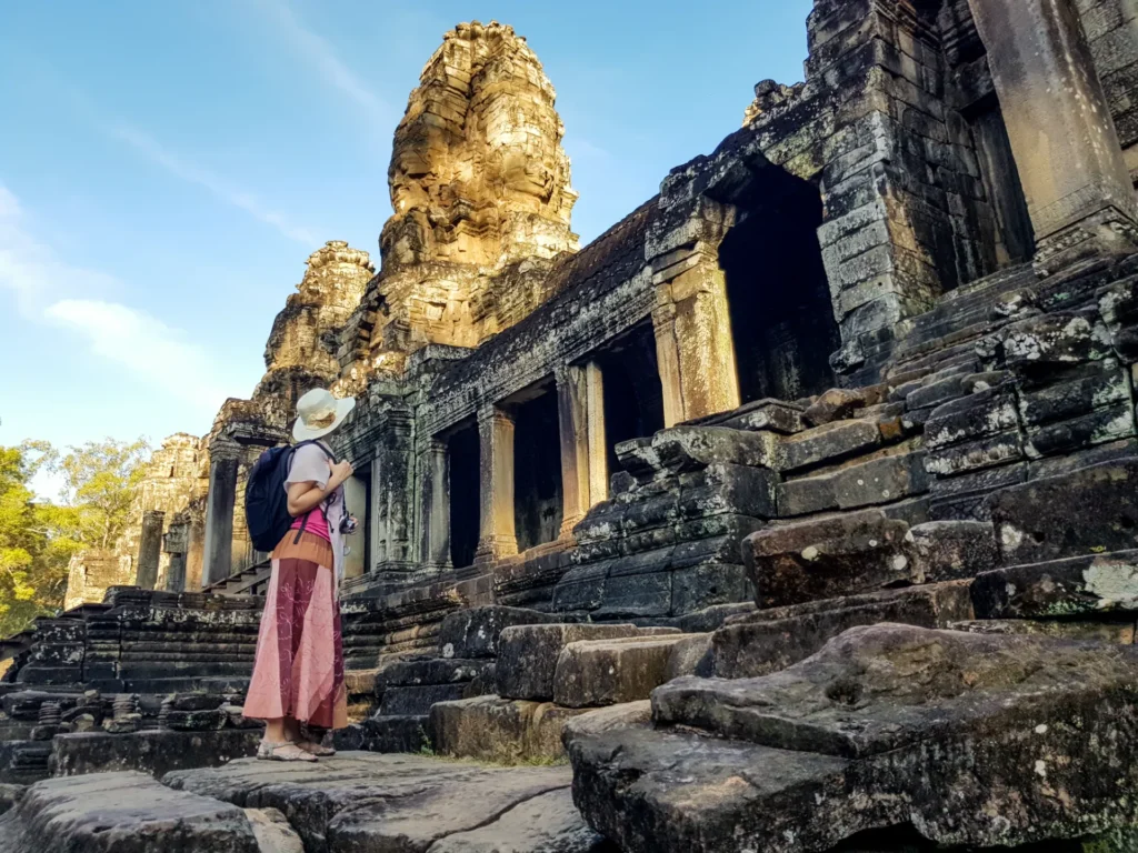 Woman tourist in front of Bayon temple in Angkor Wat