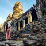 Woman tourist in front of Bayon temple in Angkor Wat