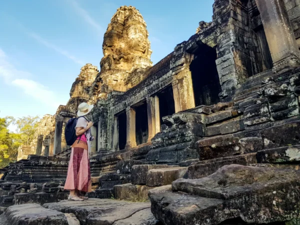 Woman tourist in front of Bayon temple in Angkor Wat
